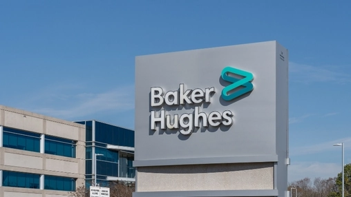 Baker Hughes company monument sign with teal chevron logo displayed outside an office building under blue sky
